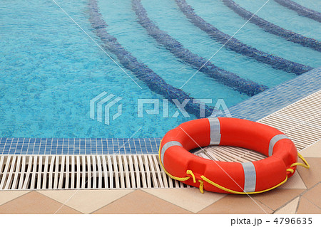 red lifebuoy with yellow ropes on tiled floor near swimming pool red lifebuoy with yellow ropes on tiled floor near swimming pool 4796635