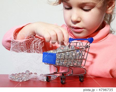Cute little girl care play with toy shopping trolley filled by s 4796735