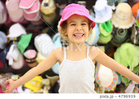 portrait of little girl trying pink panama in store and smiling, portrait of little girl trying pink panama in store and smiling, 4796939