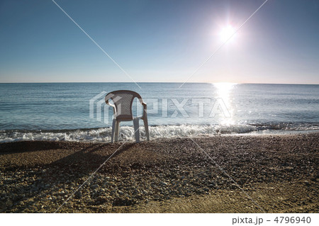 In morning ashore white empty plastic chair costs at seaside In morning ashore white empty plastic chair costs at seaside 4796940