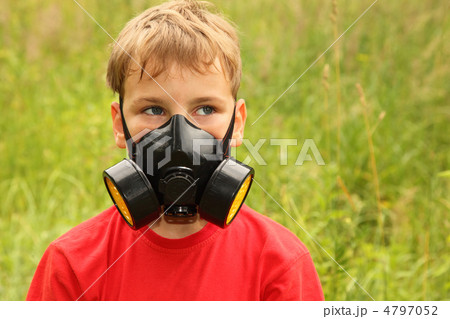little boy in red shirt with black respirator on face is in natu little boy in red shirt with black respirator on face is in natu 4797052