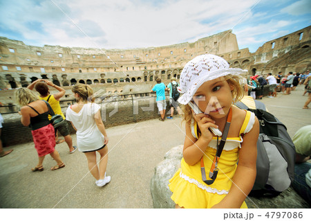 Little girl in yellow dress and white panama keeps electronic gu 4797086