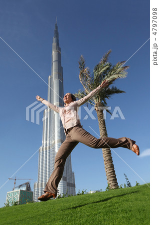DUBAI - APRIL 17: Burj Dubai skyscraper, woman jumping in front DUBAI - APRIL 17: Burj Dubai skyscraper, woman jumping in front 4797098