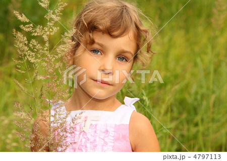 beautiful little girl in pink dress stands in tall grass on natu beautiful little girl in pink dress stands in tall grass on natu 4797113