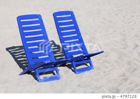 Two empty plastic chairs stand under sunbeams in  day-time on sa 4797128