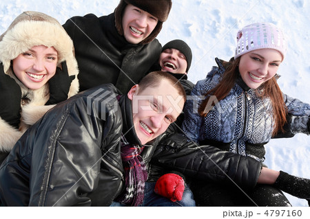 Young people by winter day lie on snow in heap and laugh Young people by winter day lie on snow in heap and laugh 4797160