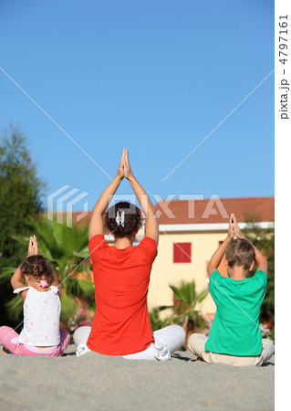 Woman with two children sit turn  back on sand in  pose of yoga 4797161
