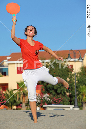 Woman jumps with tennis racket on beach by sun day Woman jumps with tennis racket on beach by sun day 4797179