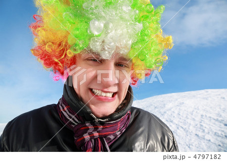 Fellow in wig of clown stands by winter day and smiles 4797182