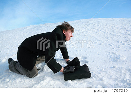 Young man creeps on all fours on snow with brief-case Young man creeps on all fours on snow with brief-case 4797219