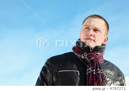 Fellow in jacket concentrated looks in distance on winter blue Fellow in jacket concentrated looks in distance on winter blue 4797271