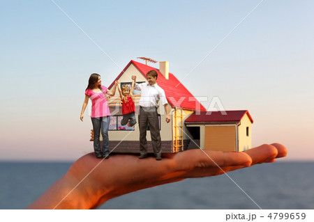 model of house with garage on hand against sea and family with g model of house with garage on hand against sea and family with g 4799659