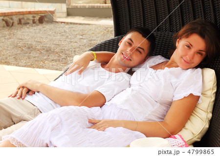 young husband and wife in white dress sitting on black wicker ch young husband and wife in white dress sitting on black wicker ch 4799865