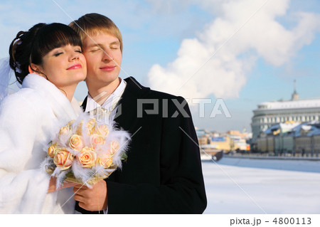 embracing smiling groom and bride with closed eyes holding bouqu embracing smiling groom and bride with closed eyes holding bouqu 4800113