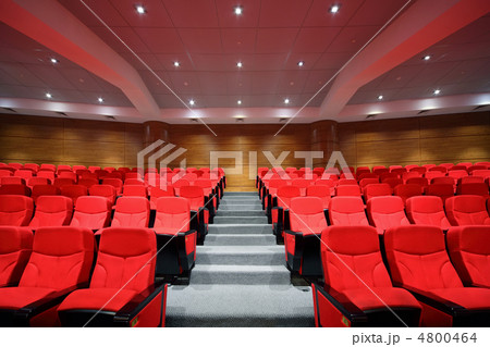 Rows of red arm-chairs are in empty hall Rows of red arm-chairs are in empty hall 4800464