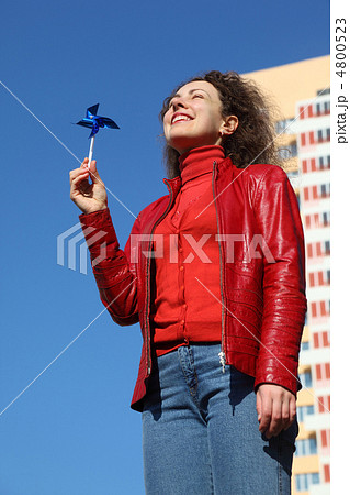 beautiful young woman in red jacket and blue jeans playing with beautiful young woman in red jacket and blue jeans playing with 4800523