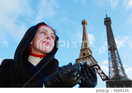 beautiful young woman holding souvenir, view of Eiffel Tower at beautiful young woman holding souvenir, view of Eiffel Tower at 4800524