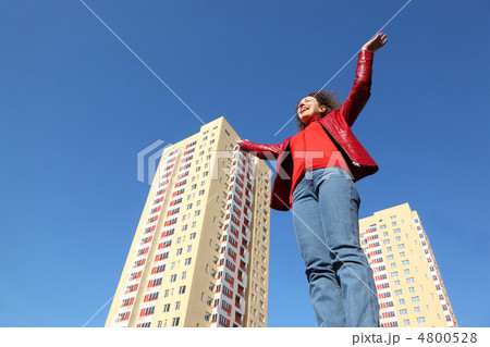 beautiful young woman in red jacket and blue jeans raises his ha beautiful young woman in red jacket and blue jeans raises his ha 4800528