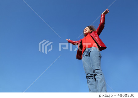 beautiful young woman in red jacket and blue jeans raises his ha beautiful young woman in red jacket and blue jeans raises his ha 4800530