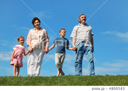grandfather and grandmother standing on green lawn and holding f grandfather and grandmother standing on green lawn and holding f 4800583