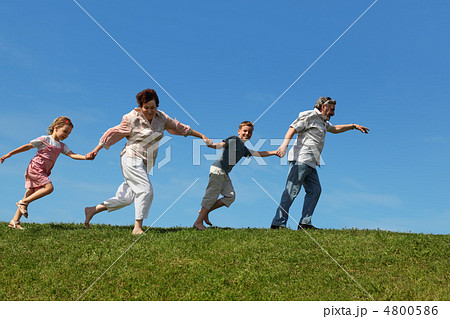 grandchildren and their grandparents running on lawn and holding grandchildren and their grandparents running on lawn and holding 4800586