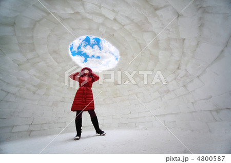 beautiful young woman in red jacket standing inside igloo at win 4800587