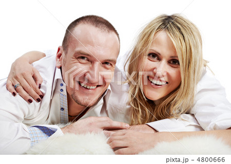 Closeup man and woman in white shirts lie embracing on the white Closeup man and woman in white shirts lie embracing on the white 4800666