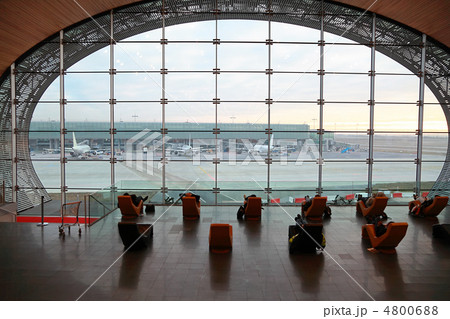 People in waiting room at airport are looking on airplanes and r 4800688