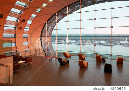 People at waiting room sitting on orange chairs in airport, airp 4800696