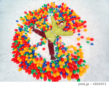 Little girl lying in snow and playing with colored balls at wint Little girl lying in snow and playing with colored balls at wint 4800953