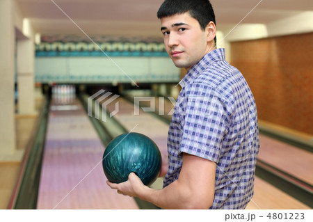 Young man stands sideways and and holds  ball for bowling 4801223