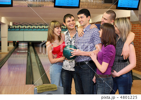 One fellow holds ball for bowling and his friends stand alongsid 4801225