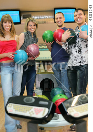Fellows and girls stand near tenpin bowling with balls for playi Fellows and girls stand near tenpin bowling with balls for playi 4801243
