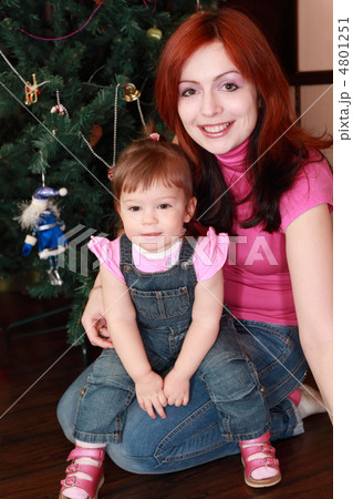 young beautiful mother and little daughter sitting on floor near 4801251
