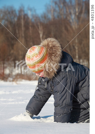little boy crawls in snow on nature at winter, white snow, trees 4801396