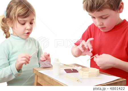 little girl and boy in red T-shirt crafts at small table, girl t 4801422