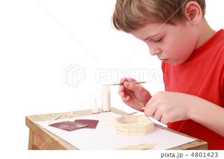little boy in red T-shirt crafts at small table, glue, side view little boy in red T-shirt crafts at small table, glue, side view 4801423