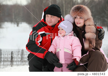father hugs mother and little daughter at snow, they looks into father hugs mother and little daughter at snow, they looks into 4801543
