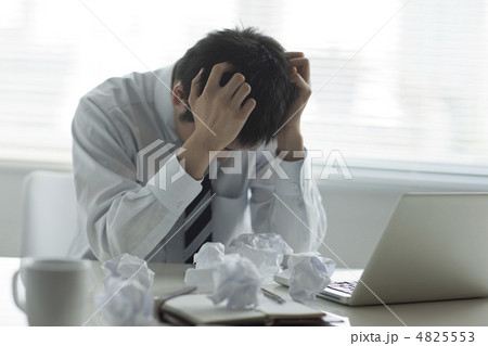 頭を抱える男性の写真素材