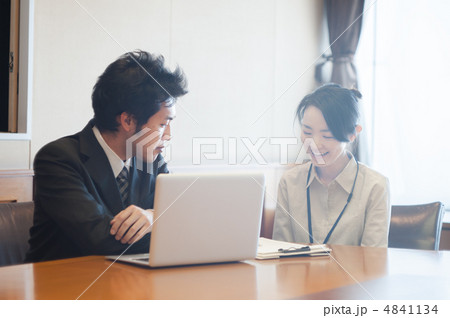 ノートパソコンと資料の前で会話する男性サラリーマンと女性 ノートパソコンと資料の前で会話する男性サラリーマンと女性 4841134