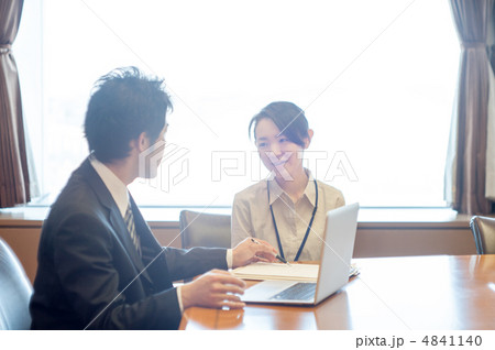 ノートパソコンと資料の前で会話する男性サラリーマンと女性 ノートパソコンと資料の前で会話する男性サラリーマンと女性 4841140