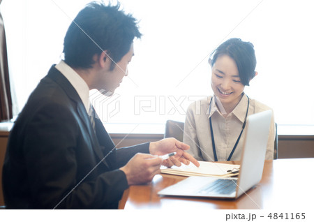 ノートパソコンと資料を見ながら会話する男性サラリーマンと女性 ノートパソコンと資料を見ながら会話する男性サラリーマンと女性 4841165