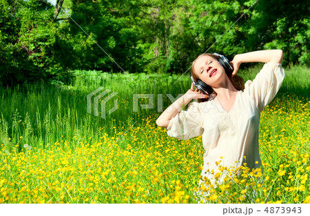 beautiful girl in headphones enjoying the music in a field of fl beautiful girl in headphones enjoying the music in a field of fl 4873943