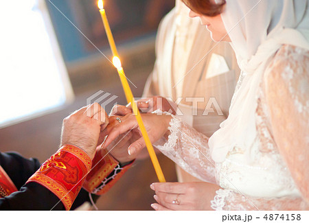 Priest is putting ring on bride's finger during orthodox wedding 4874158
