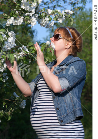Pregnant woman touching flower Pregnant woman touching flower 4874228