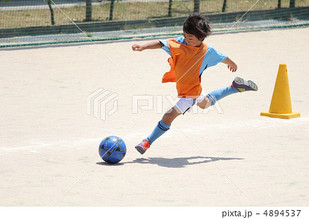 サッカー少年の躍動感あふれるキックシーンの写真素材