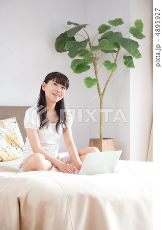 ベッドの上でPCを見る女性 4895927