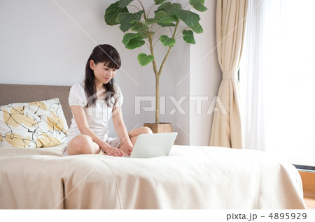 ベッドの上でPCを見る女性 4895929