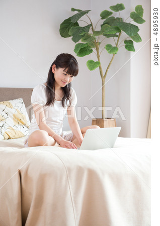 ベッドの上でPCを見る女性 4895930