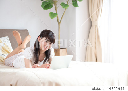 ベッドの上でPCを見る女性 4895931